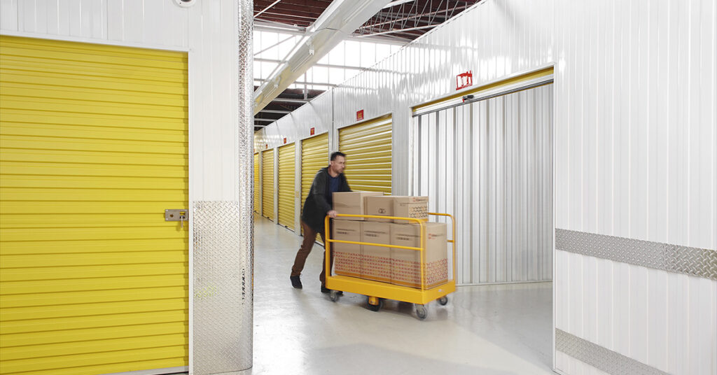 Customer of Wilson Storage, transporting goods on a pallet jack to a roller door secure, indoor storage unit.